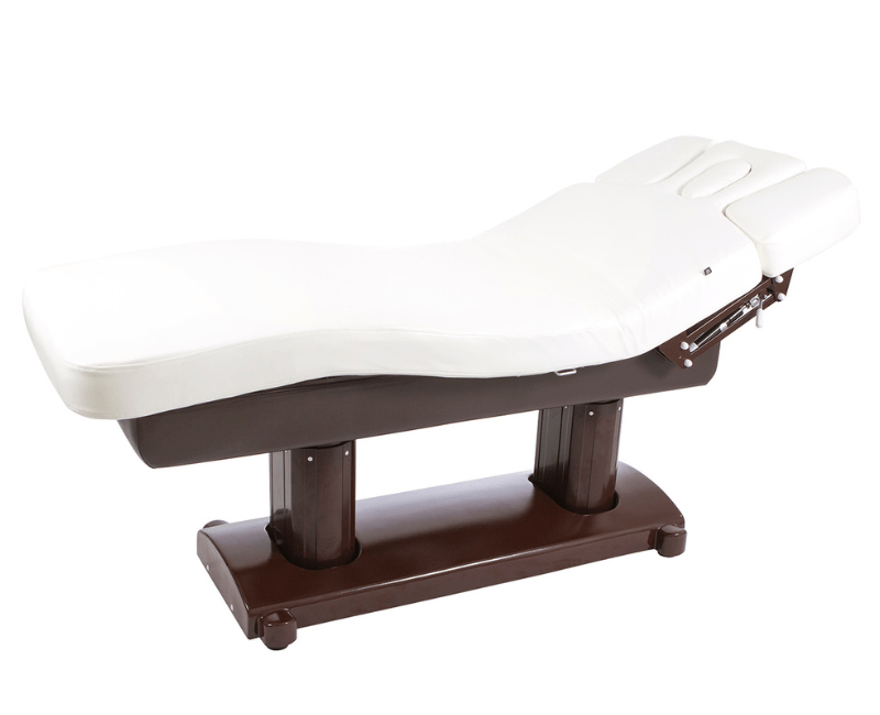 White padded massage table with a dark brown base and adjustable headrest at one end.