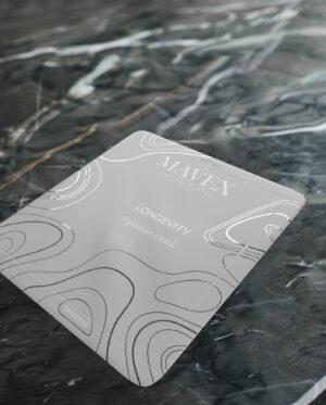 Mavex-infusion-mask-longevity-anti-age | ATE Bordeaux Close-up of a MAXFLEX Longevity infusion mask packaging on a dark marble surface, showing white abstract lines and 'SWISS MADE' label.