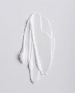 A dollop of thick white cream smeared on a white background.