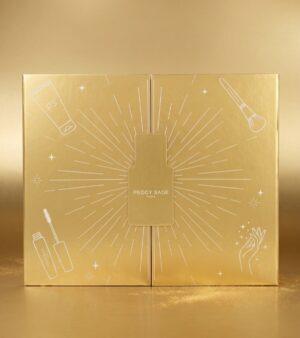 104511 | ATE Bordeaux Gold-toned makeup gift box with a central rectangular bottle design and sunburst lines, Peggy Sage Paris text in the center.